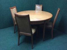 A circular teak G-plan dining table and four chairs