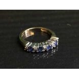 A 9ct gold sapphire and diamond half hoop ring