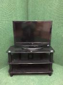 An Alba 26 inch LCD TV with remote on smoked glass TV stand together with a Sony dvd player