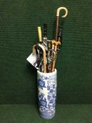 A blue and white oriental stick stand and a large quantity of walking sticks, Shepherd's crook,