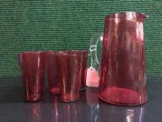 An early twentieth century cranberry glass jug together with five beakers (6)