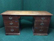 A Victorian pine knee hole desk fitted with six drawers