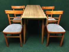 A mid twentieth century melamine drop leaf table and four chairs