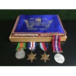 A collection of four WWII medals with ribbons and a box of Royal Navy embroidered pouch