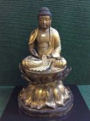 An impressive 19th century Chinese gilt and lacquered wood figure of a seated buddha,