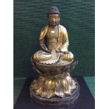 An impressive 19th century Chinese gilt and lacquered wood figure of a seated buddha,