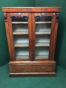 A Victorian mahogany glazed door bookcase fitted with a drawer beneath