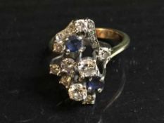 A sapphire and diamond cluster ring, the stones in raised claw settings, set in platinum,