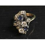 A sapphire and diamond cluster ring, the stones in raised claw settings, set in platinum,