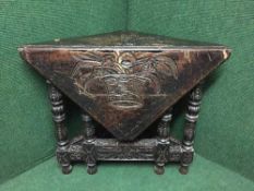 A nineteenth century heavily carved oak flap sided table