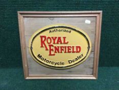 A cast iron Royal Enfield motorcycle dealer plaque on pine board