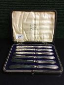 A set of six cased sterling silver butter knives