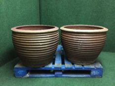 A large pair of terracotta ribbed planters