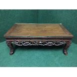 An Oriental carved low table with plate glass top