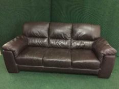 A brown leather three seater settee and an electric reclining armchair