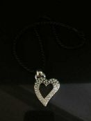 A white gold and diamond set heart pendant on rope, the diamonds weighing an estimated 2.