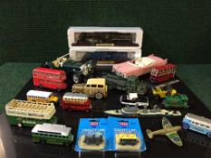 Box of assorted die cast buses and cars together with two model trains on wooden plinths