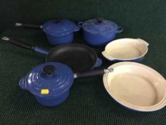 Three Le Creuset cast iron lidded pans together with a cast iron sauce pan and two oven dishes