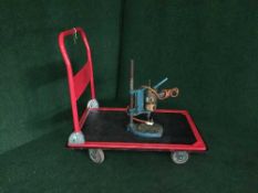A flat bed trolley together with drill on stand