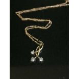 A 9ct gold three stone diamond necklace