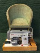 A cased Jones electric sewing machine together with a child's green loom chair