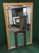 A large pine framed bevelled mirror together with a mahogany mirror