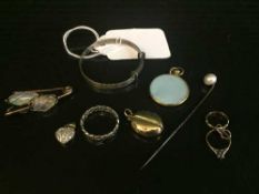 A collection of eight items of jewellery including silver baby's bangle, white metal ring,