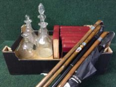 A box of three cut glass decanters, bundle of walking sticks,