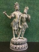 An antique Tibetan bronze figure depicting Buddha with four arms by a lady,