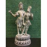 An antique Tibetan bronze figure depicting Buddha with four arms by a lady,