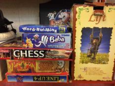 A quantity of assorted board games, dart board in cabinet, framed Newcastle United print,