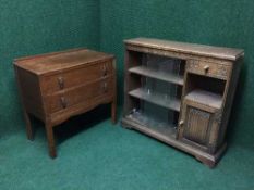 A carved oak sliding door bookcase and an oak two drawer chest