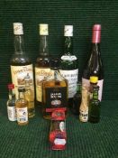A basket of assorted bottles of Scotch whiskey, bottle of wine, bottle of rum,