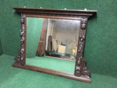 An early twentieth century heavily carved oak overmantel mirror