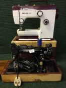 A cased Singer electric sewing machine, one other,