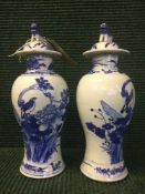 A pair of oriental blue and white lidded porcelain vases