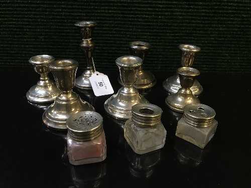 A collection of silver candlesticks,