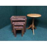 A nest of three hardwood tables together with a pine pedestal table