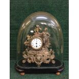 A late 19th century gilt metal mantel clock with pendulum under glass dome