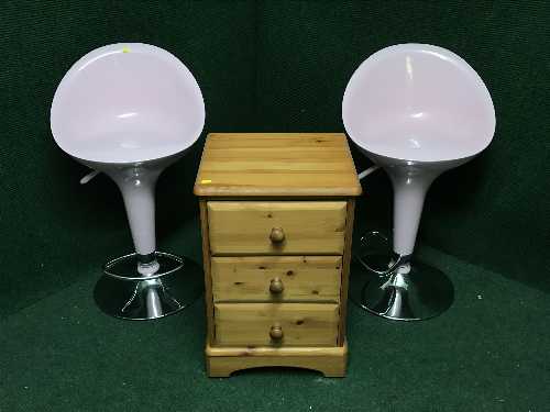 A pine three drawer bedside chest and a pair of pink and chrome bar stools