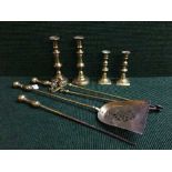 A three piece brass companion set together with two pairs of brass candleticks