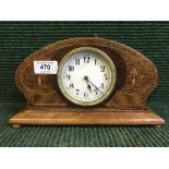 An inlaid oak mantel clock on brass feet