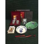 A tray of boxed commemorative silver Panda coin, postcards, oriental tea brick,