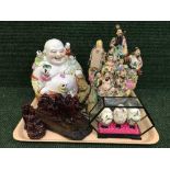 A tray of oriental figures, hand painted eggs in display case,