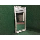 A contemporary silvered framed bevelled mirror