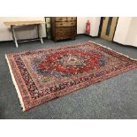 A fringed Persian carpet on red ground