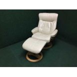 A contemporary cream leather relaxer chair with stool