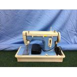 A Merit cased electric sewing machine together with a roll of material
