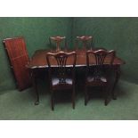 A mahogany extending dining table with leaf together with a set of four chairs
