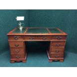 A yew wood pedestal desk with green leather inset,